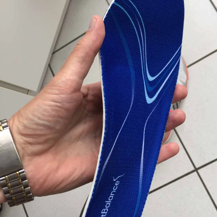 A moulded insole with a firm arch shell photographed from the side