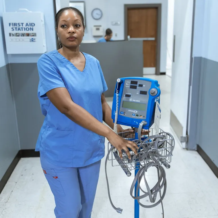 A healthcare worker standing through a shift in a hospital corridor